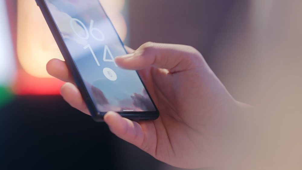 A user unlocks a smartphone, illustrating mobile device security